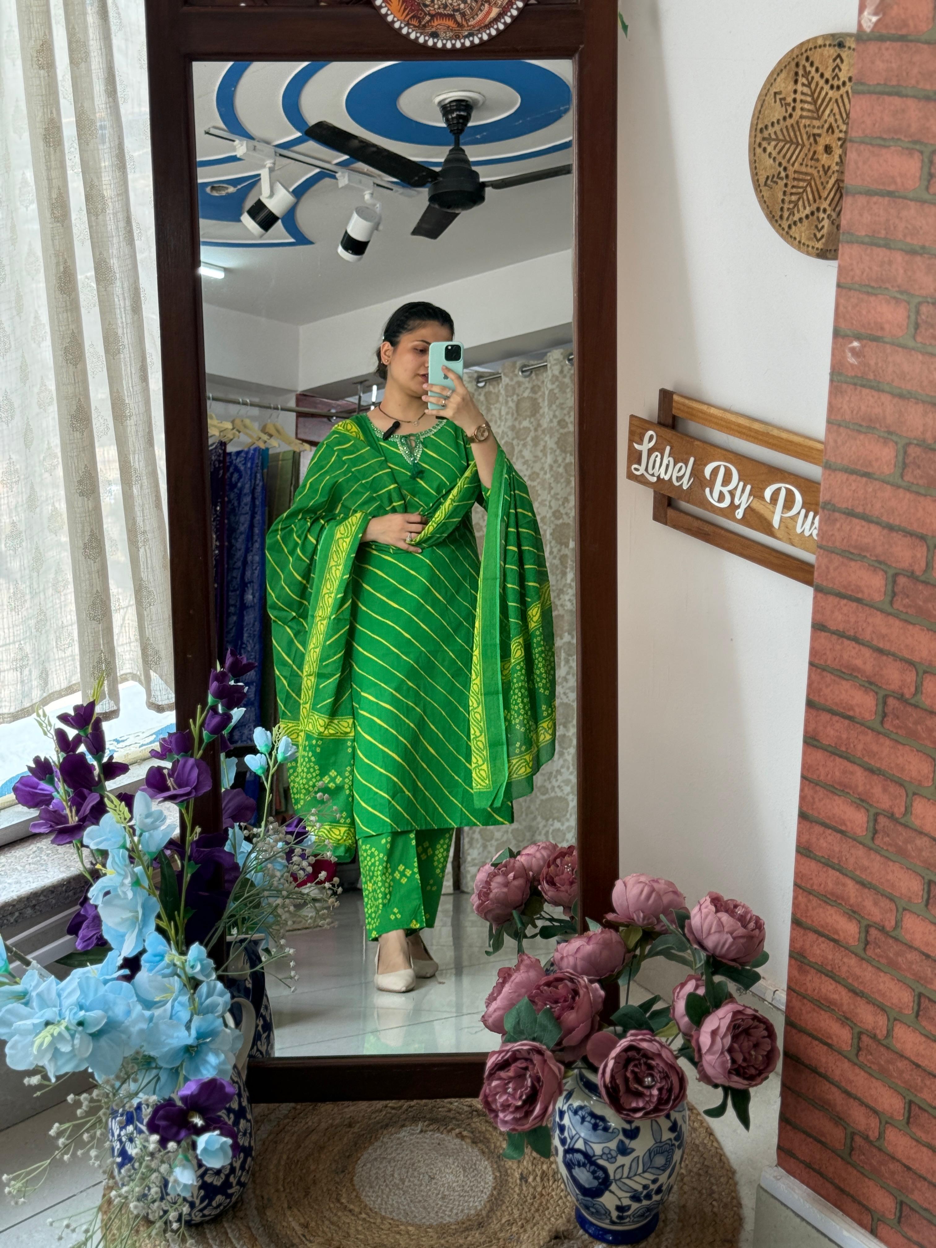 Woman wearing a green Leheriya and Bandhani cotton suit set with matching printed straight pants and coordinated dupatta by Label by Pushp